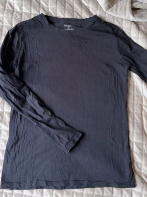 Svart långärmad tröja Primark S - En enkel svart långärmad tröja från Primark Cares med rund hals och stretchigt material. Perfekt basplagg som funkar till allt och är riktigt skön tack vare den mjuka bomullsblandningen.