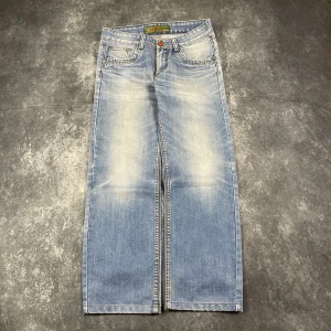 Ljusblå vintagejeans för herr i storlek W32 L32 från 2000-talet - Ljusblå vintagejeans för herr från 2000-talet, angiven storlek W32 L32. W/L är uppskattningar baserade på måtten.  Mått 📏 Midja: 42 cm Benslut: 21 cm Lår: 31 cm Totallängd: 102 cm Måtten hittas även på bilderna  Leverans inom 24 timmar Spara på priset och frakten genom att sätta ihop ett paket Mer information finns på min profil. 9-640