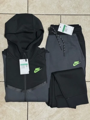 Nike tech tracksuit  - Nike loungewear set med hoodie och byxor i svart och mörkgrått. Helt ny. Storlek M