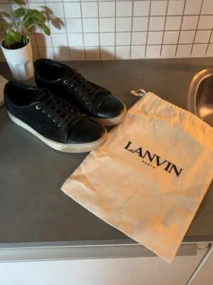 Svarta Lanvin  - Säljer ett par Lanvins som jag inte använder ofta längre. De är i fint skick som man kan se på bilderna men det syns att de använts. Hör av er vid minsta fråga. Dustbag medföljer. Passar strlk 44-45