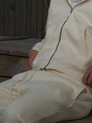SOULMARK TRACKSUIT BEIGE  - Krämfärgad hoodie med dragkedja och huva. Hoodien har ribbade muddar, fickor på sidorna och en avslappnad passform. Tillverkad i mjukt material som ger en chill vibe och passar perfekt till streetwear-stilen. Hoodie och byxor ingår, oversized! S,M,L,XL finns. Kan fraktas i hela Sverige 
