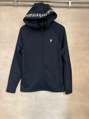 Peak performance cardigan/zip - Peak Performance rider zip  Stilren Peak Performance zip i mörkblå färg. Clean och sportig design som passar perfekt både till vardags och för en mer avslappnad outfit.  • Peak Performance • Mörkblå • Zip • Storlek: S • Skick: NYTT, iprincip oanvänd!  Skickas fort!😊