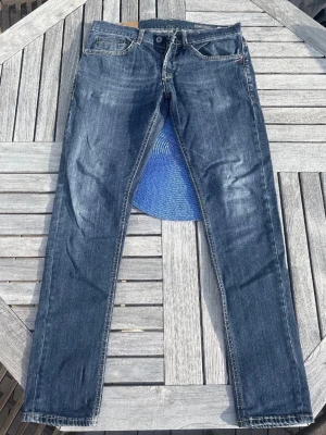 Dondup George Jeans – W32/33 – Slim Fit Premium Denim - Säljer ett par stilrena Dondup George jeans i snygg mörkblå tvätt med riktigt bra passform. Slim fit modell med stretch som sitter clean på kroppen och funkar både till vardag och mer uppklätt.  Storlek: W32 Passar även W33 beroende på fit/stretch. Midja ca 41 cm platt Ytterben ca 99 cm  Mycket bra skick utan större defekter. Klassiska premiumjeans med fina Dondup-detaljer och snygg tvätt.  Perfekta om du gillar designer denim och Stockholmstil fits.  Pris kan diskuteras vid snabb affär. Skriv g