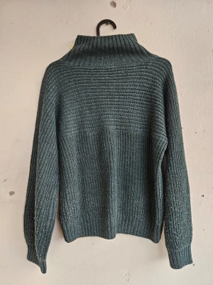 Mörkgrön stickad polotröja Monki XS - Mysig mörkgrön stickad tröja med hög krage från Monki.. Lite nopprig som man ser på sista bilden, men annars väldigt fint skick.