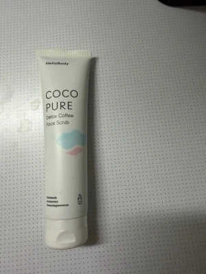 HelloBody Coco Pure Face Scrub - HelloBody Coco Pure Detox Coffee Face Scrub är en ansiktsskrubb i vit tub med svart text och pastellfärgade detaljer. Innehåller 100 ml och är vegansk samt parfymfri. Perfekt för dig som vill rengöra huden på djupet med naturliga ingredienser. Ny och aldrig använd.