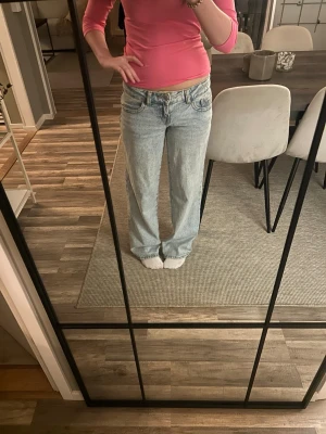 Ljusblå baggy jeans med låg midja - Säljer ett par ljusblå jeans med baggy passform och låg midja. Jeansen har klassiska fem fickor och är tillverkade i denim med en avslappnad look. Perfekta för dig som gillar en casual och trendig stil.