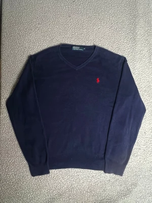 Mörkblå  tröja Polo Ralph Lauren - Fin tröja, fint skick. Inga hål eller liknande.   Mått: Längd-61cm Armlängd-57cm Midjebredd-43cm