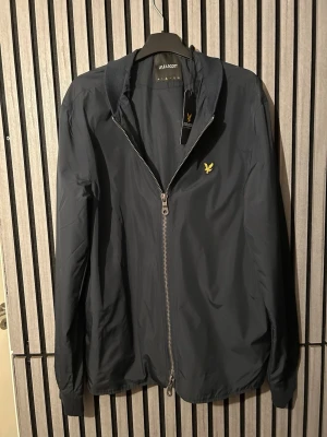 Svart bomberjacka från Lyle & Scott - Stilren mörkblå bomberjacka från Lyle & Scott med lapparna kvar (helt oanvänd) den är förstår på mig är 180