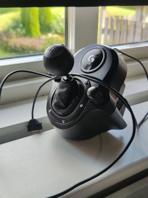 Logitech växelspak till spelkonsol - Säljer en svart Logitech växelspak för spelkonsol eller PC. Den har en rund växelspaksknopp, detaljer i konstläder och plast samt USB-anslutning. Perfekt för racing- och bilspel för en mer realistisk spelupplevelse. Fungerar på alla moderna spelkonsol 