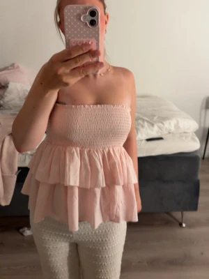 Ljusrosa volang kjol / topp - Supersöt ljusrosa bandeau topp med smock upptill och dubbla volanglager. 