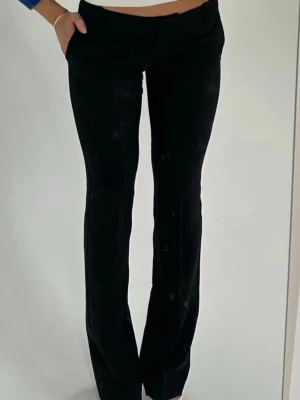 Svarta kostymbyxor - Snygga svarta kostymbyxor med rak passform och normal midja. Byxorna har diskreta fickor i sidorna och är tillverkade i ett mjukt, vävt tyg som ger en stilren look. Perfekta för dig som gillar en clean och klassisk stil.