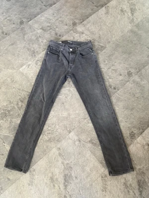 Grå raka jeans från Replay - Snygga grå jeans från Replay i modellen Grover med rak passform och klassisk femficksdesign. Jeansen har en diskret tvättad look och är tillverkade i ett mjukt bomullsmaterial med lite stretch för extra komfort.