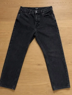 J&J relaxed jeans - Säljer ett par svarta relaxed fit jeans från Jack & Jones, modell Chris. Jeansen har klassisk femficksdesign, bälteshällor och knappgylf. 