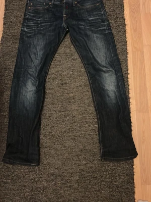 Blåa jeans - Jag säljer ett par blåa jeans från replay. Dem har snygga fades och passar perfekt till alla olika stunder. Midjan = 42cm, längd = 99,5 cm, ben öppning = 19 cm. Skriv om funderingar!
