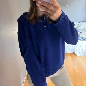 Mörkblå stickad tröja - Säljer en snygg mörkblå stickad tröja med flätade detaljer på ärmarna. 