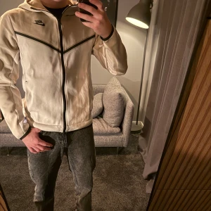 Beige nike tech fleece  - Säljer en snygg beige tech fleece från Nike för endast 850kr. Både tröja och byxa är i storlek small och är i bra skick. Både tröjan och byxan har en stilren design med svarta detaljer och en ficka på ärmen. Perfekt för både vardagslivet och vid sportsammanhang. Köpt på jd sports för ca 2000kr om jag minns rätt. Bara att höra av dig om du har några funderingar 🙌🏼 Pris kan diskuteras vid snabb och smidig affär. Hela tracksuiten för 850kr, annars tröja 500kr och byxa 450kr. 