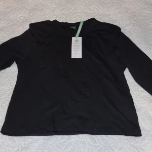 Svart långärmad tröja från H&M, st S - Säljer en stilren svart långärmad tröja från H&M. Perfekt för en  klassisk look. Tröjan har en normal passform och är tillverkad i ett mjukt material för extra komfort.