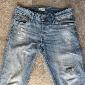Slitna jeans från Jack & Jones - Jack & Jones jeans med slitningar. Storlek W32 L34, är 180 lång. Bra skick, pris kan diskuteras!