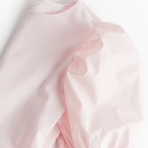 Ljusrosa topp med puffärmar - Säljer en söt ljusrosa topp med puffiga kortärmar. Perfekt för en feminin och stilren look. Toppen har en rund halsringning och är tillverkad i ett mjukt material.