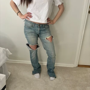 Ljusa jeans med slitningar från Acne - Skit snygga jeans med slits från Acne i den perfekta ljusblåa färgen! De är i storlek W29 L32! Hon på bilden är ca 157 cm!!! (Jeansen har tidigare spruckit därav priset, men det är igen sytt vilket inte syns när de är på!!) 