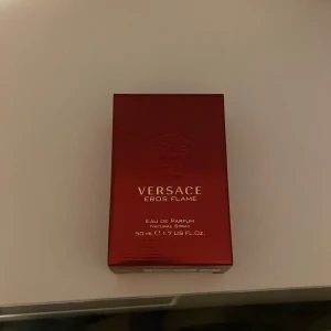 Versace Eros Flame Eau de Parfum - Versace Eros Flame Eau de Parfum i en elegant röd förpackning. Flaskan är mörk med guldlock och rymmer 50 ml. En doft som utstrålar passion och intensitet. Den är helt oanvänd 