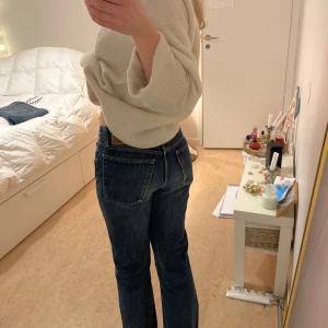 Blå jeans från Croker Jeans Co - Snygga blå jeans från Croker Jeans Co med klassisk femficksdesign och knappgylf. De har en rak passform och är perfekta för en avslappnad stil. Jeansen har en mörkblå tvätt och orange sömmar som ger en cool kontrast.