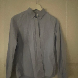 Blå skjorta från Pinpoint Oxford - Snygg blå skjorta från Pinpoint Oxford med klassisk krage och knappar framtill. Perfekt för en stilren look. Passar både till vardags och mer formella tillfällen.