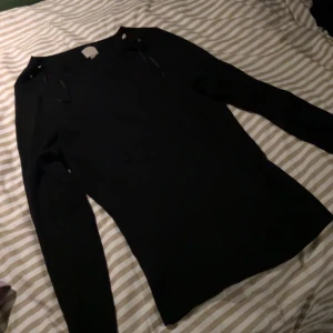 Svart tröja med knappar - Tjock svart tröja med silvriga knappar vid axeln. Säljs pga att den inte används🥰Den har en liten tråd som sticker ut vid magen men det är inget som syns så mycket