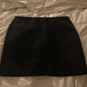 Svart kortkjol  - Jätte snygg och stilren kort svart kjol från H&M. Kjolen har dragkedja där bak.                              Helt oanvänd med prislapp kvar. Säljer pga att jag köpte två🥰