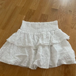 Minikjol Chelsea  - Minikjol från Chelsea med volanger och broderi, den har en innerkjol. 