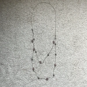 Långt halsband från LBVYR med pärlor - Snyggt långt halsband i silverfärgad metall från Lbvyr med två rader. Dekorerat med ljusrosa facetterade pärlor och silvriga kulor som ger en cool och stilren vibe. Perfekt accessoar för att lyfta din outfit.