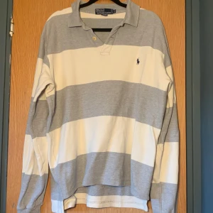 Långärmad piké Ralph Lauren, Medium - Vit och grå randig långärmad piké från Ralph Lauren i storlek M. Ganska stor i storleken. Bra skick.