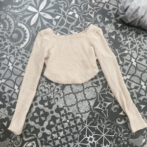 Beige croppad stickad topp - Superfin croppad topp i beige med lång ärm och fyrkantig ringning. ☀️