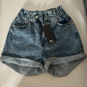 Blå jeansshorts  - Snygga blå jeansshorts i storlek XS. De är aldrig använda och har fortfarande prislappen kvar. Perfekta för sommaren och lätta att matcha med allt. 