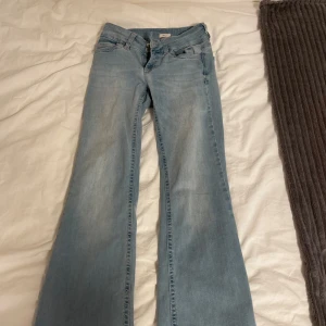 Ljusblå bootcut jeans från Nelly - Säljer ett par ljusblå bootcut jeans från Nelly! Som du kan se så är de vissa defekter längs med vid benen, de kommer från när jag skulle sprätta upp de då jag tidigare hade sytt upp de nån cm och sedan ville försöka ändra de. Det är också en JÄTTE liten fläck, en liten liten svart prick på byxorna, jag vet inte om de går bort i tvätten, men oavsett så syns den inte när man har på sig dem. Jeansen köptes i januari, och har använts en del men inte så mycket, säljer pga blivit för små!