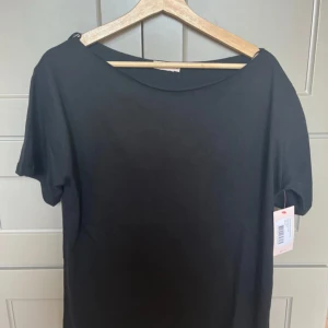 Svart slouchy t-shirt från Nelly - Svart t-shirt från Nelly i modellen Slouchy Shoulder Tee. T-shirten har en lös passform, korta ärmar och är helt oanvänd med etiketten kvar köpte den för 199kr