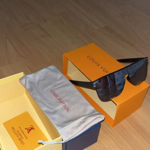  svarta monogram solglasögon - Snygga svarta solglasögon f med spegellins och ikoniskt monogram över hela glaset. Sköldformad modell med breda skalmar och exklusiv känsla. Kommer med originalbox, fodral och certifikat.