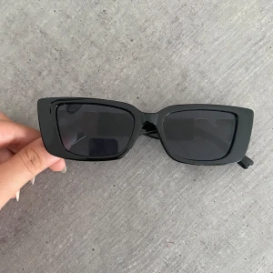 Solglasögon; Svarta cat eye solglasögon med gulddetalj - Säljer dessa snygga svarta solglasögon i cat eye-modell  Perfekta för att lyfta vilken outfit som helst!