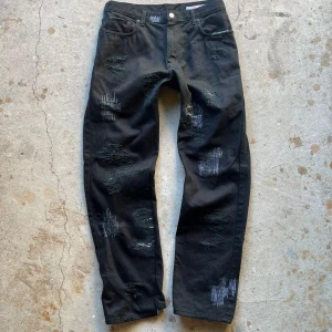 Distressed Jeans - Distressed jeans med lagningar överallt. Straight fit.