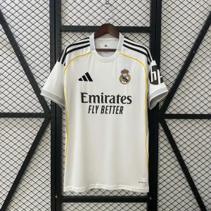 Real Madrid vit matchtröja Adidas - Snygg vit Real Madrid fotbollströja från Adidas med svarta detaljer och gula inslag längs axlarna. Klassisk klubbmärke på bröstet och 'Emirates Fly Better' tryckt framtill. Tillverkad i lätt och ventilerande material, perfekt för träning eller match.