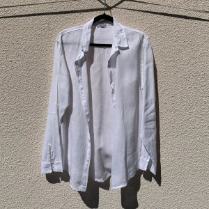 Vit linneskjorta från Moda Helene - Säljer en klassisk vit skjorta i 100% linne från Moda Helene. Skjortan har långa ärmar, krage och knäppning framtill funkar perfekt till ett par shorts eller linnebyxor. Storlek M. Aldrig använd. Gjord i Italien 