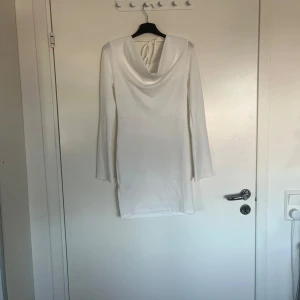 Vit klänning med draperad hals - Säljer en stilren vit klänning från 157 i storlek XS. Klänningen har en elegant draperad hals och långa ärmar, perfekt för en chic look. Materialet är mjukt och bekvämt, vilket gör den idealisk för både vardag och speciella tillfällen. Passa på att förnya garderoben med denna snygga klänning! 🤍