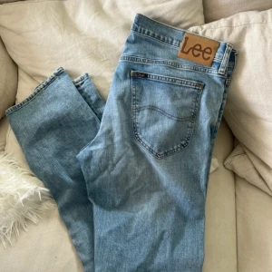 Lee Daren ljusblå jeans W34 L32 - Säljer ett par klassiska Lee Daren jeans i ljusblå tvätt. Modellen har raka ben, normal passform och dragkedjegylf. Snygga detaljer med Lee-logga på bakfickan och läderpatch i midjan. Perfekta för en avslappnad stil. Knappt använda 