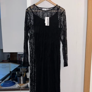 Svart lång spetsklänning Kappahl - Säljer en svart långklänning från Kappahl i transparent spets med långärmad design. Klänningen har rund halsringning och ett elegant, figurnära snitt. Perfekt för dig som vill sticka ut med en stilren och trendig look.