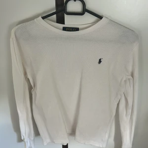 Vit långärmad tröja Polo Ralph Lauren - Säljer en stilren vit långärmad tröja från Polo Ralph Lauren. Tröjan är i bomull med diskret struktur och har den klassiska broderade loggan på bröstet. Den är äkta! Köpt för ungefär 400kr säljer för 120kr, använd 2 gånger men har nån fläck som knappt syns🩷 skriv för frågor eller för nedsättning av pris💓