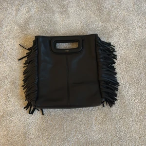 Svart maje handväska - Cool svart handväska i skinn från Maje. Nästan inte använd alls. Köpt nere i saint tropez. Super fin med klass. Inget band komme till! 