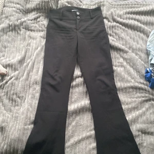 Svarta bootcut-byxor från Gina Tricot - Svarta utsvängda kostymbyxor. Lågmidjade och väldigt snygga, använda men syns inte💕