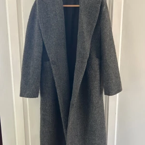 Grå ullkappa från Gina Tricot XS - Säljer en lång, grå kappa från Gina Tricot i storlek XS. Kappan har en oversized passform, bred krage och är tillverkad i ullblandning. Perfekt för höst och vinter när du vill vara både varm och stilren.