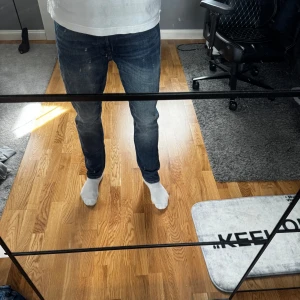 Mörkblå jeans från Jack & Jones - Säljer ett par mörkblå jeans från Jack & Jones Jeans Intelligence, modell Comfort/Mike. Klassisk femficksdesign med raka ben och snygga slitningar. 