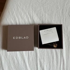 Guldigt fyrklöverarmband från Edblad - Supersnyggt armband från Edblad med ett hängsmycke i form av ett fyrklöver. Kedjan och klövern är i guldig ton och ger en elegant och trendig look. Perfekt accessoar för att lyfta din outfit och ge lite extra tur. Aldrig använd, lådan följer med